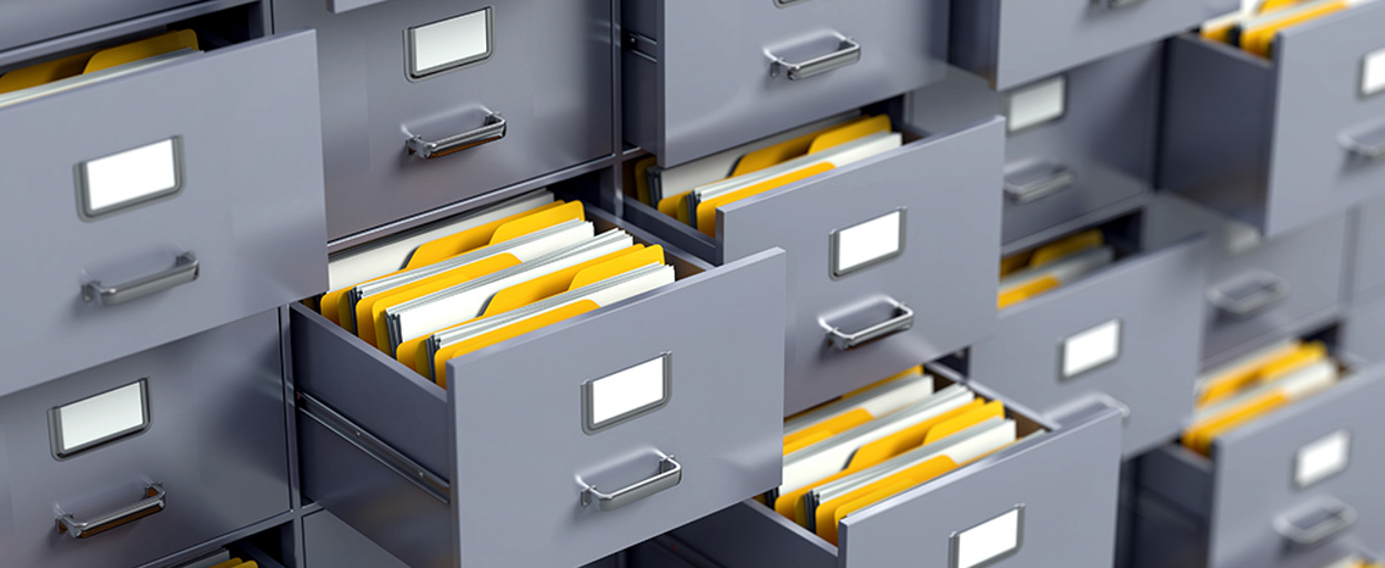 Wall of filing cabinets half open with yellow folders