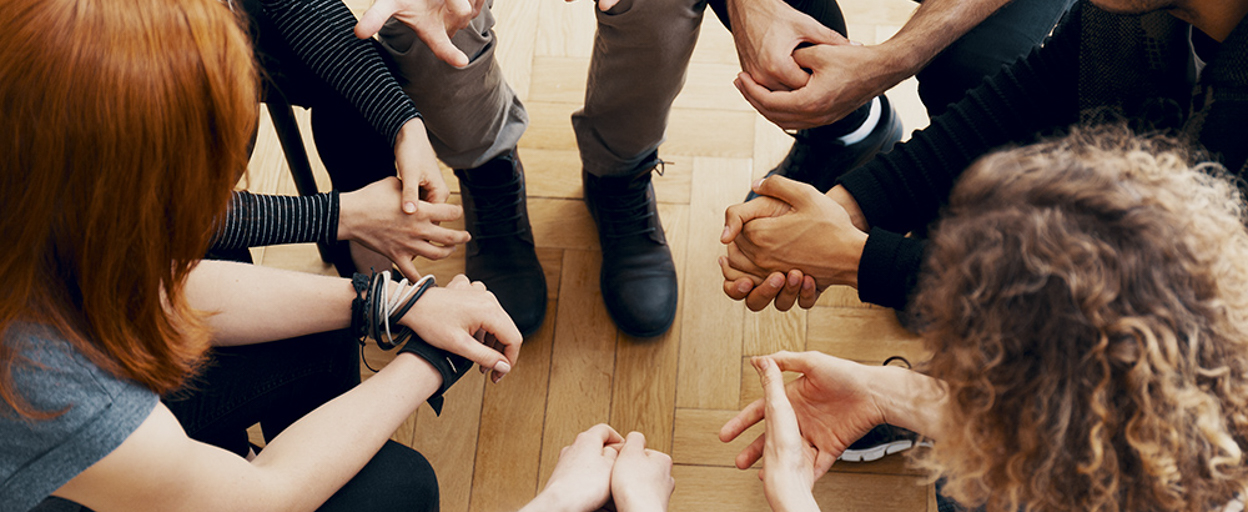 Group of people in chairs leaning in to each other