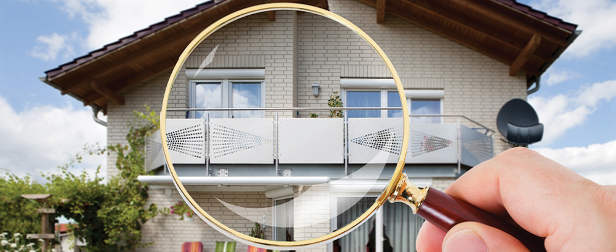 Front of house with magnifying glass held up in front