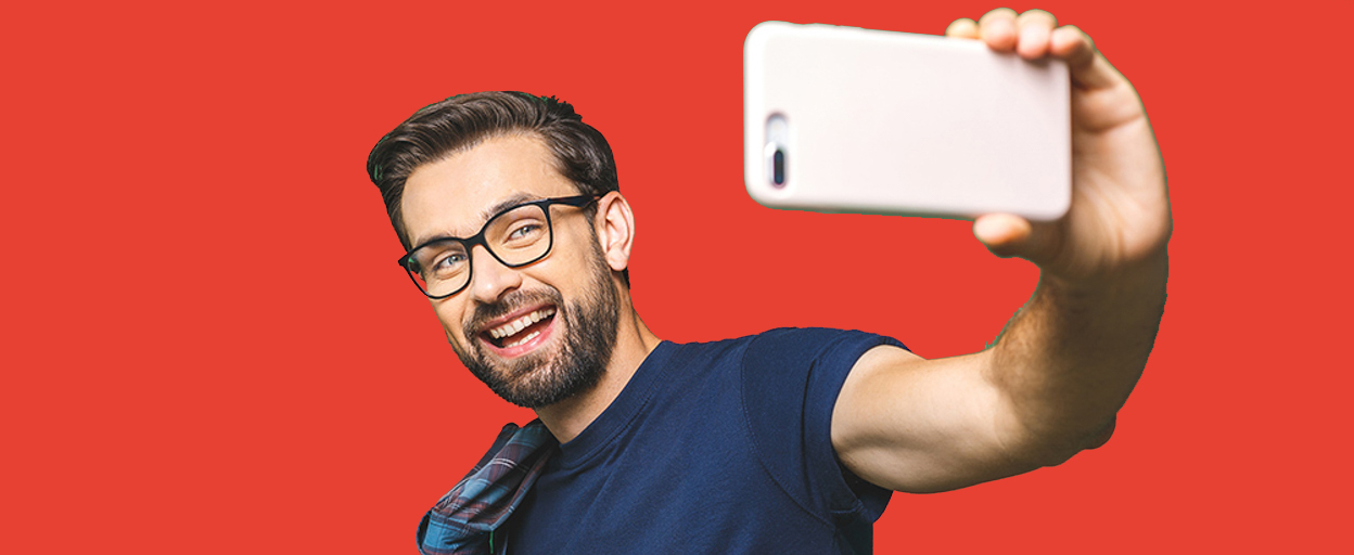 Man taking selfie in front of red background