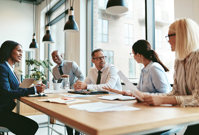 Group of people at desk with paperwork discussing