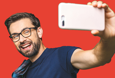 Man taking selfie in front of red background