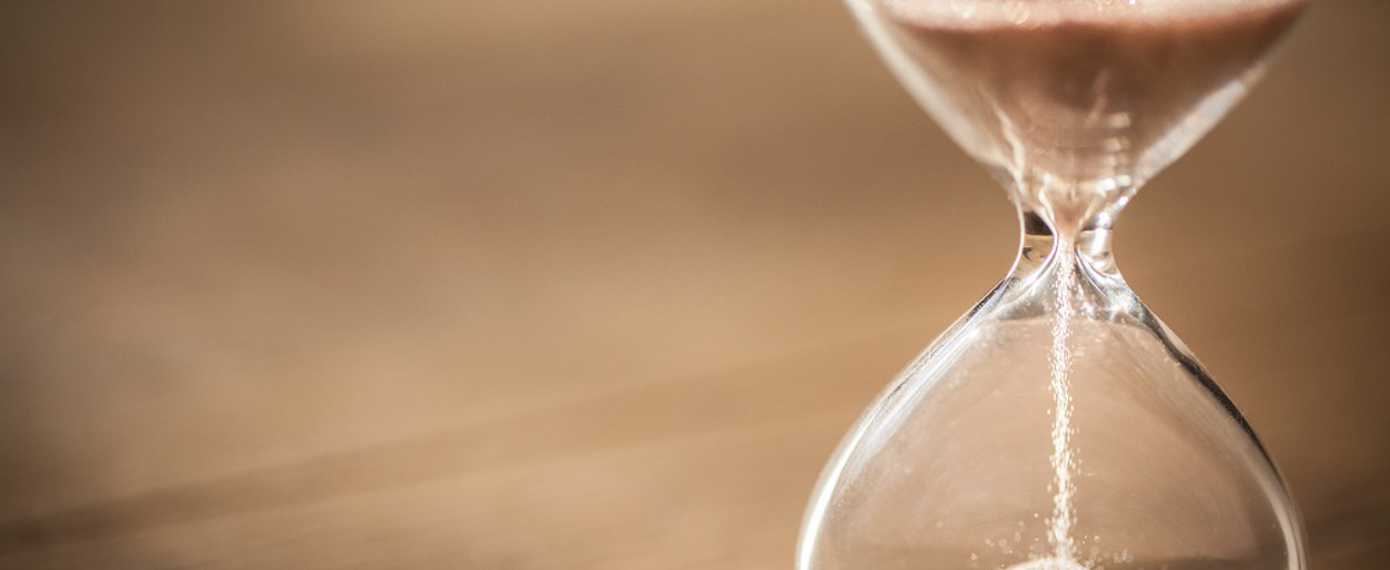 Hourglass ticking down to 1 January 2022|Inspecting a smoke alarm