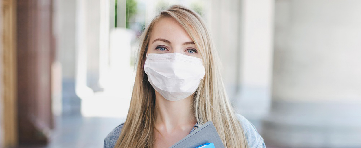 Woman with white mask in front of pillars
