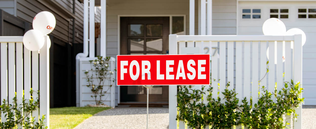 A for lease sign in the front yard of a residential property