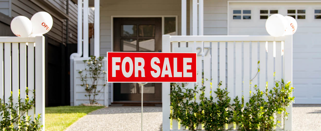 A For sale sign in front of a residential property